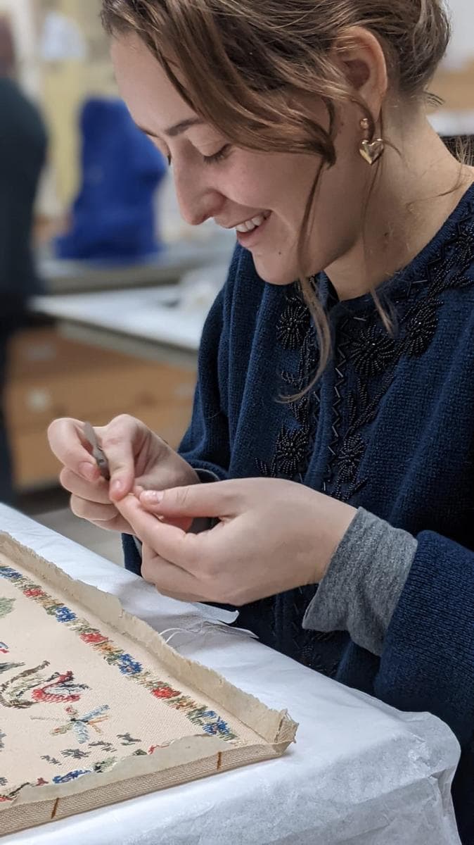 Instructor demonstrating textile preservation techniques during a workshop